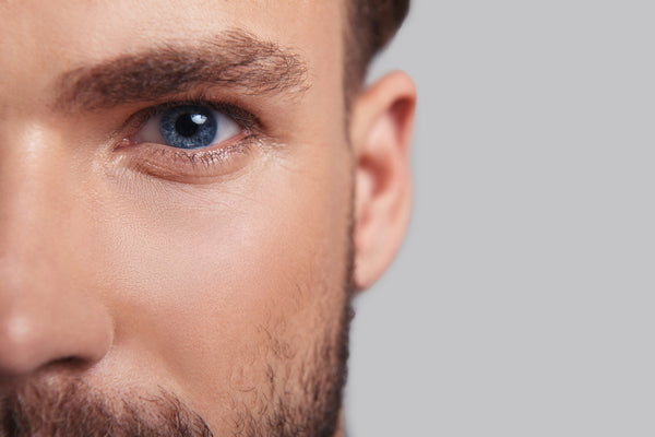 The Ingredients That Matter for Men's Skin (and the ones you can skip). Close up of half a handsome man's face focusing on his beautiful eyes