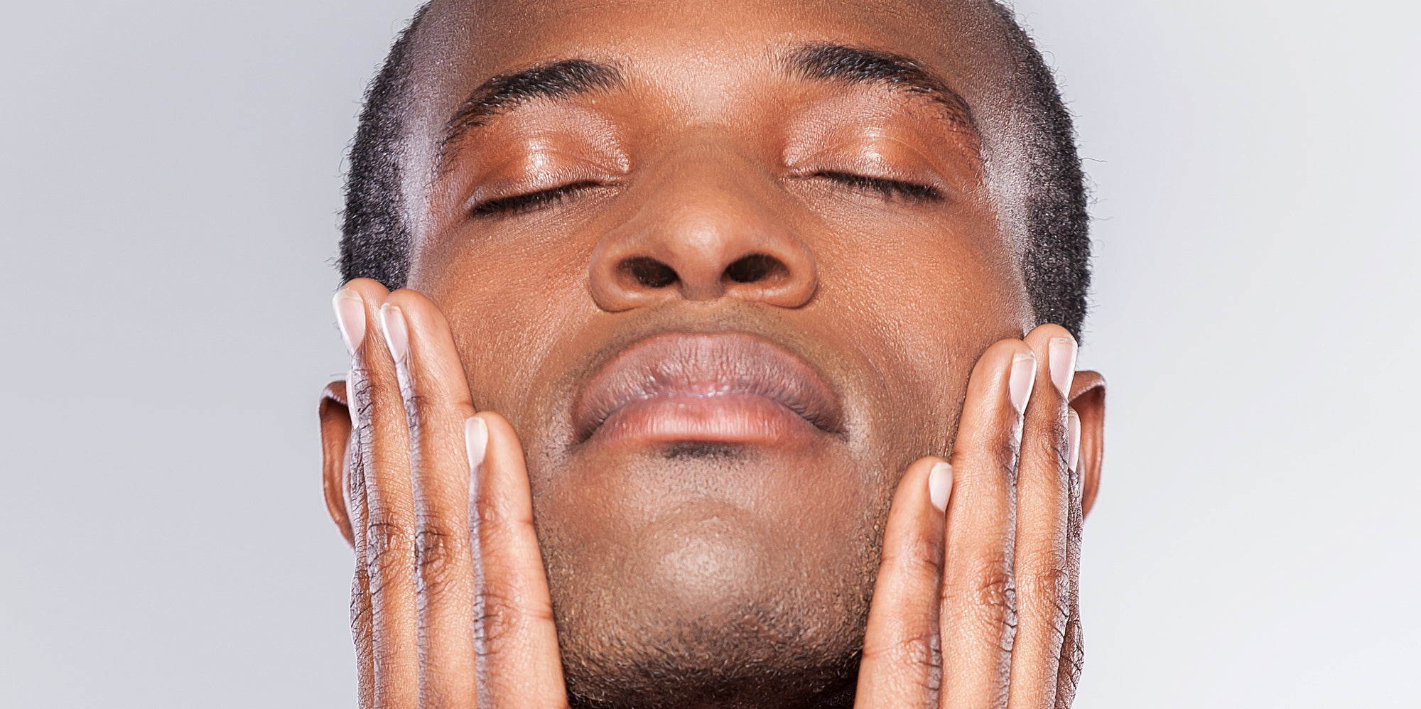 Your Anti Aging Shaving Routine. Handsome man feeling his smooth face