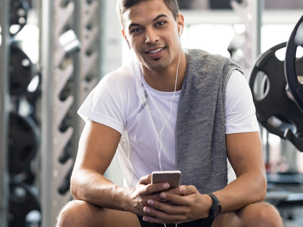 Healthy guy at gym, white t-shirt, smiling