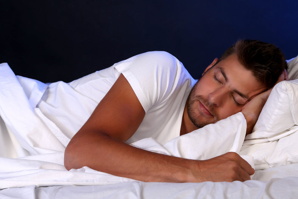 Beauty Sleep – How Your Skin Reflects Your Rest. Image of man sleeping on white bedding