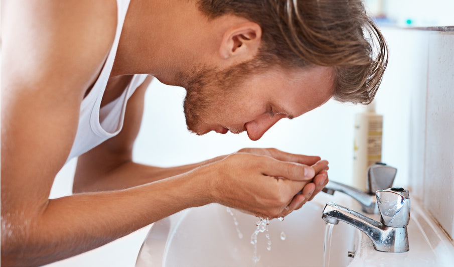 Why Skincare Routines Fail - and How to Make Yours Work. Close up of handsome man washing his face at white sink