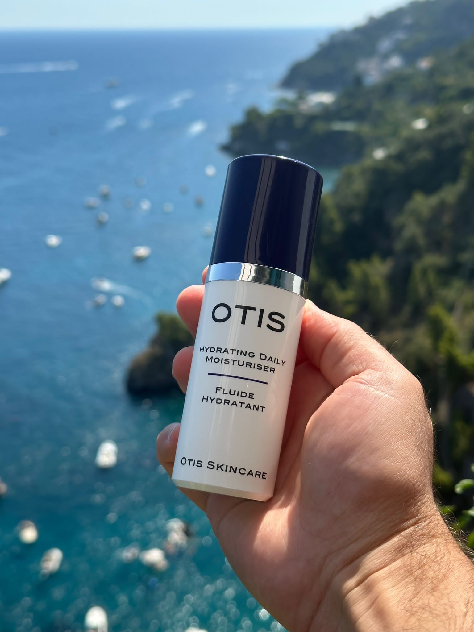 hand holding moisturizer in summer sunshine on amalfi coast