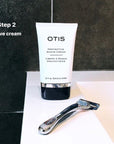 Tube of OTIS Protective Shave Cream with chrome razor against charcoal gray tiles